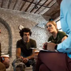 Grupa żołnierzy uczestniczy w sesji terapeutycznej, wspierając się nawzajem w procesie resocjalizacji.