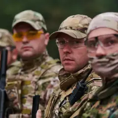 Kapral i jego drużyna w kamuflażu, gotowi do akcji. Wszyscy mają na sobie gogle ochronne i czapki.