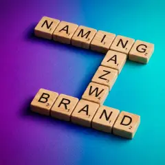 Drewniane klocki z literami tworzą słowa "NAMING" i "BRAND". To klucz do sukcesu każdej firmy.
