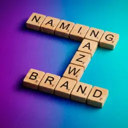 Drewniane klocki z literami tworzą słowa "NAMING" i "BRAND". To klucz do sukcesu każdej firmy.