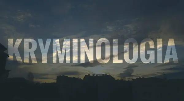 Napis KRYMINOLOGIA na tle zachodzącego słońca nad miastem.