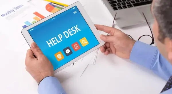 Intendent korzysta z tabletu z aplikacją Help Desk. Na ekranie widnieją ikony: ustawienia, czat, dokumenty i wyszukiwanie.