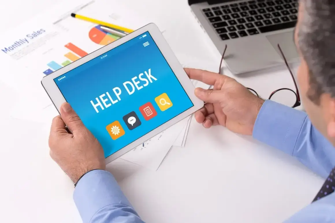 Intendent korzysta z tabletu z aplikacją Help Desk. Na ekranie widnieją ikony: ustawienia, czat, dokumenty i wyszukiwanie.