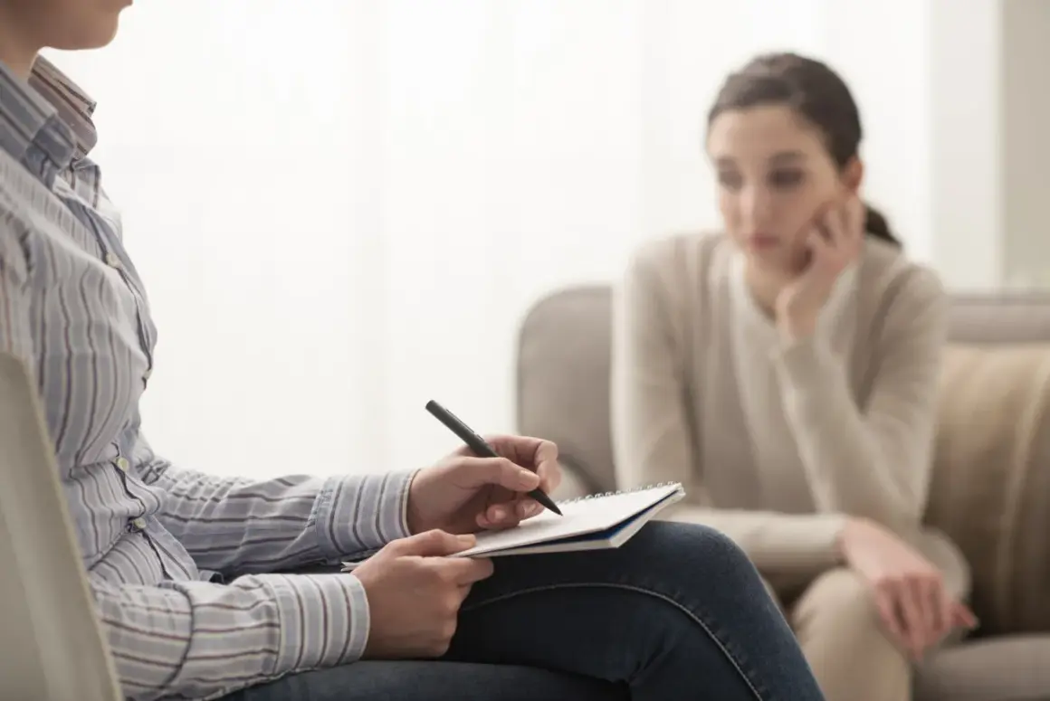 Psycholog notuje podczas sesji. Zastanawiasz się, ile zarabia psycholog? To zależy od doświadczenia i specjalizacji.