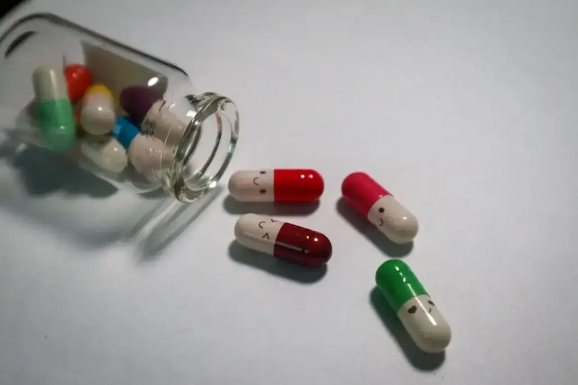 Kapsułki psychotropowe z uśmiechniętymi buźkami, jedna buteleczka przewrócona, leżą na białym tle.