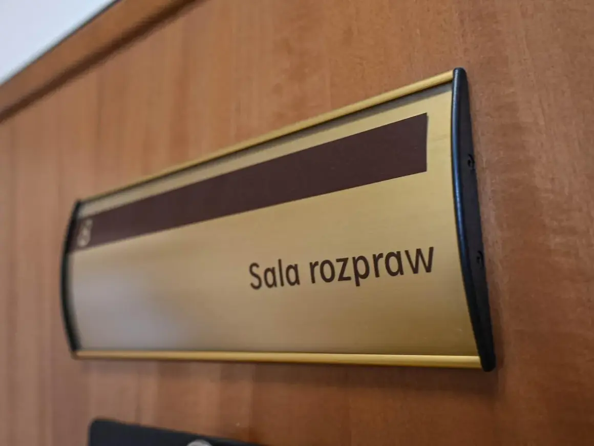 Tabliczka "Sala rozpraw" na drewnianych drzwiach. Może tu pracować referendarz sądowy.