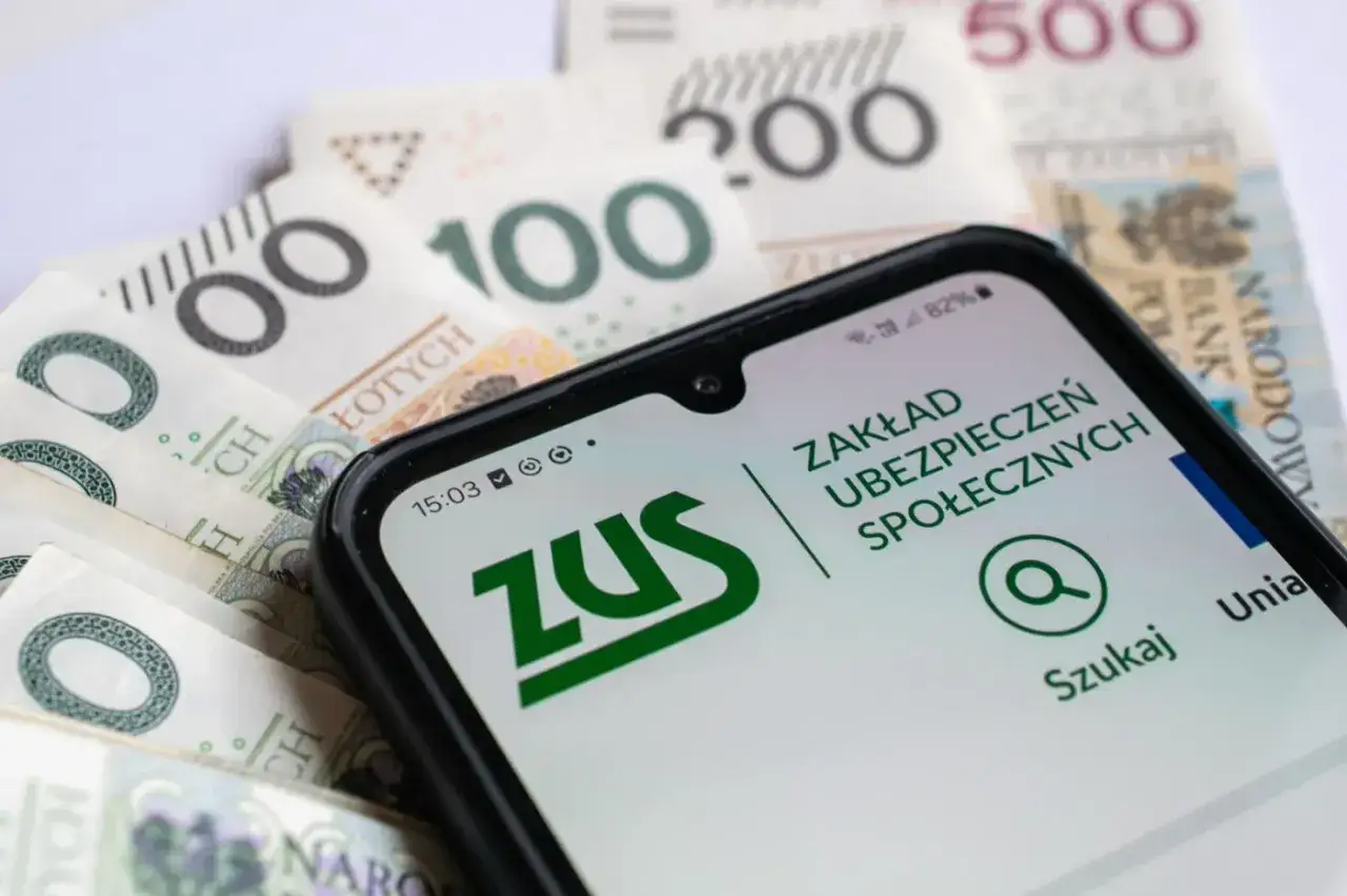 Telefon z aplikacją ZUS na tle polskich banknotów. Planowanie odprawy emerytalnej i finansów.